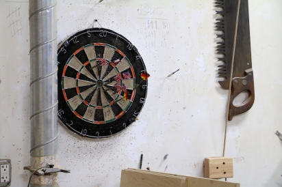 Friendly ongoing game of darts in the Bronx Wood Works workshop 