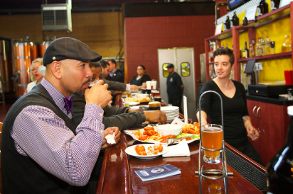 Ruben Diaz Jr enjoying wings and beer with Edible Bronx at the Chelsea Craft Brewing Company ribbon cutting